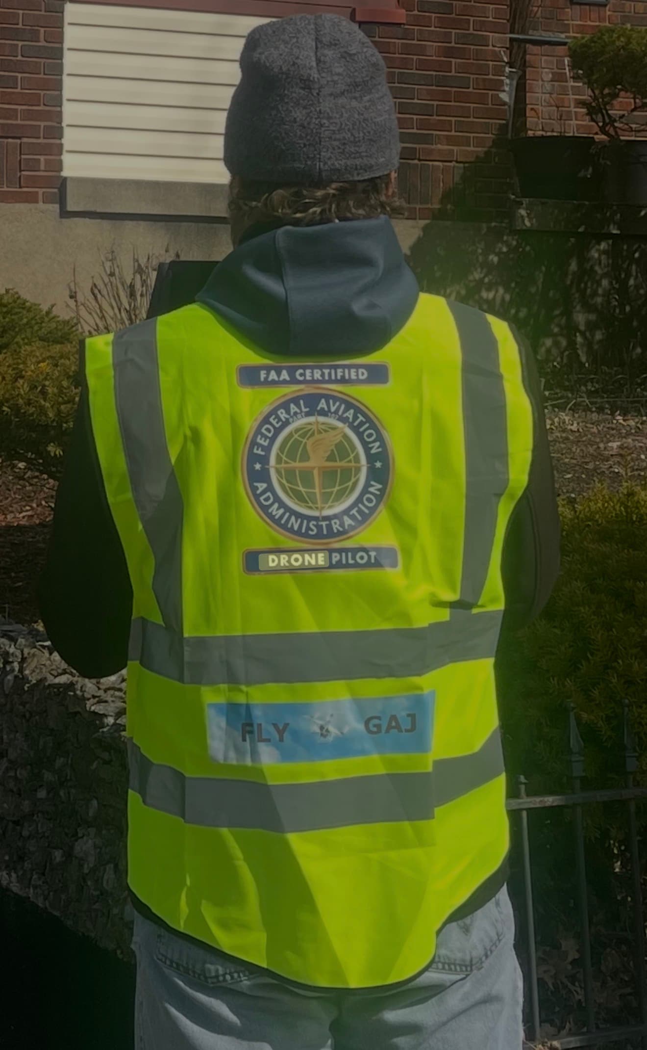 Close-up of the FAA certification and drone pilot identification on the field inspector's high-visibility vest